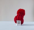 Close up conceptual miniature model house with red wool scarf hat on wooden background Royalty Free Stock Photo