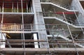 Close up of a concrete building under construction surrounded by scaffolding with exposed stairs and floors Royalty Free Stock Photo