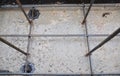 A close-up on concrete foundation reinforcement with iron bars, mesh of steel bars