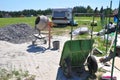 Close up on concrete mixer, cement mortar mixing with construction wheel barrow on house construction site Royalty Free Stock Photo