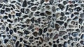 A close-up of a concrete surface embedded with numerous polished, dark pebbles, creating a rough, textured, Royalty Free Stock Photo