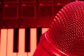 Close up of condenser pro microphone with piano keyboard on background. Copy space. Red room studio Royalty Free Stock Photo