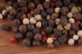 Close up of condiment on brown wooden background. Bunch of different peppers on table with space for your text.