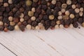 Close up of condiment on white wooden background. Bunch of different peppers on table with space for your text. Royalty Free Stock Photo