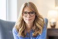 Close-up of confident middle aged woman looking at camera  while relaxing indoor Royalty Free Stock Photo