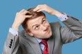 Close-up of confused businessman touching head with funny face