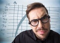 Close up of confused man with glasses against blue graph and blurry blue wood panel