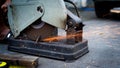 Close up a construction worker cuts off metal fittings with a grinder.