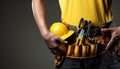 Close-up of construction worker with helmet and tool belt on dark background Royalty Free Stock Photo