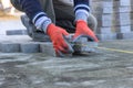 Close-up of construction worker installing laying pavement cement bricks on sidewalk Royalty Free Stock Photo