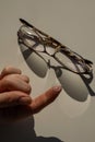 Close-up of a contact lens on a female index finger against the background of glasses on a white table. Royalty Free Stock Photo