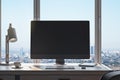 Close up of contemporary designer workplace in modern office interior with blank mock up computer screen, window with beautiful