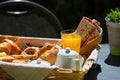 Close Up of continental breakfast with orange juice, tea and fresh croissants on table top surface in summer garden background Royalty Free Stock Photo