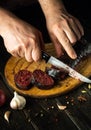 Close-up cook hands with a knife cut blood sausage on a kitchen cutting board. Cooking a national dish with spices at home in Royalty Free Stock Photo