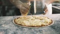 Close up for cook& x27;s hands grating cheese on the pizza Four Cheeses.Chef adding the ingredients to the pizza Royalty Free Stock Photo