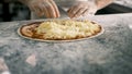 Close up for cook& x27;s hands putting cheese on the pizza Four Cheeses.Chef adding the ingredients to the pizza Royalty Free Stock Photo