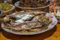 Close-up on cooked fish. Southern Chinese festivity rural food on bowls and plates at a wooden table