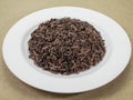 Cooked organic riceberry mixed jasmine rice on white ceramic plate