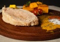 close-up of cooked pork with pumpkins on wooden plate