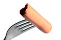 Piece of Strasbourg sausage stung on a fork over white background Royalty Free Stock Photo