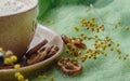 Close-up on cookies lying on a saucer near a ceramic cup of fragrant morning coffee. Nearby are yellow mimosa flowers and a