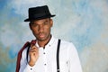 Close up cool young african american man posing with hat against wall Royalty Free Stock Photo
