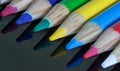 Coloured pencil crayons on a black reflective surface Royalty Free Stock Photo