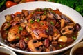 Close-up of Coq au Vin with tender chicken, mushrooms, and pearl onions in a rich red wine sauce, topped with crispy bacon