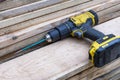 cordless screwdriver lying on a stack of wooden boards. Construction Royalty Free Stock Photo