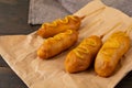 Close-up of corn dogs served with mustered sauce on paper bag at table