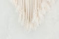 Close up of cotton macrame panel fringe in a minimalistic scandinavian wall. Texture. Background.