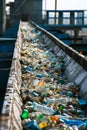 Close-up of countless plastic bottles on a recycling conveyor belt, with a blurred background.