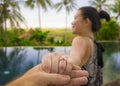 Close up couple hands holding in love with Asian woman showing diamond engagement ring celebrating marriage proposal at beautiful Royalty Free Stock Photo