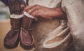 close up of couple hands holding a pair of baby boots