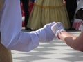 Close up of couple hands in white gloves during historical dance . Loveliness and prettiness couple of dancers