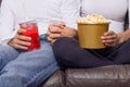 Close up of couple holding hands and watching movie. Flat closed