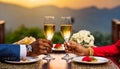 close-up of a couple holding two champagne glasses at a restaurant table. a passionate pair