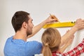 Close up of couple with level measuring wall Royalty Free Stock Photo