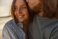 Close up of couple in love hugging and kissing while walking along the beach on sunny windy day Royalty Free Stock Photo