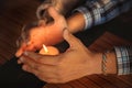 Close up of couple`s hands cupped around a burning candle. Hands of young man and woman that protect the flame of a candle. Love Royalty Free Stock Photo