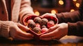 Close-up couple\'s hands heart-shaped chocolate truffles. Truffles elegantly arranged in a decorative box, sweet moment