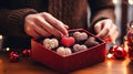 Close-up couple\'s hands exchanging heart-shaped chocolate Truffles elegantly arranged in a decorative box, sweet moment