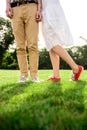 Close up of couple`s legs in keds on grass. Royalty Free Stock Photo