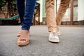 Close up of couple's legs in keds walking down street. Royalty Free Stock Photo