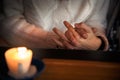 Close up of couple sitting in a cafe and holding hands together behind a wooden table with a burning candle. Love story concept Royalty Free Stock Photo