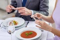 Close up of couple with smartphones at restaurant