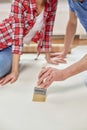 Close up of couple smearing wallpaper with glue Royalty Free Stock Photo