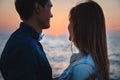 Close up of couple watching the sunrise at the beach summer time, seashore summer beach at yellow blue evening horizon sea, sunset Royalty Free Stock Photo