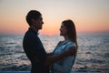 Close up of couple watching the sunrise at the beach summer time, seashore summer beach at yellow blue evening horizon sea, sunset Royalty Free Stock Photo