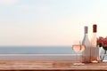 Close up of couple wine champagne glasses and bottle for celebration on wooden table with sea view and sunset sky background,